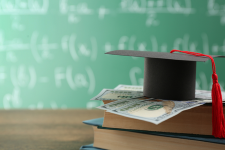 A graduation cap in front of a chalkboard.