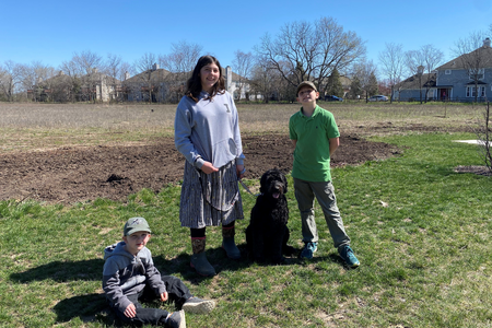 three youth and dog in field prepared to plant trees for oak savanna